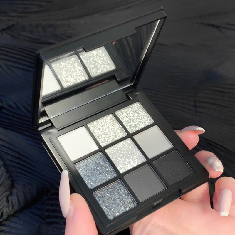 9-Color Cool Toned Smokey Shimmer Eyeshadow Palette with Matte and Glitter Options in Gray and Black.