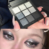 9-Color Cool Toned Smokey Shimmer Eyeshadow Palette with Matte and Glitter Options in Gray and Black.